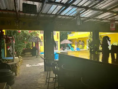 a woman sitting at a bar in a restaurant at Coco Hotel and Hostel in Sosúa