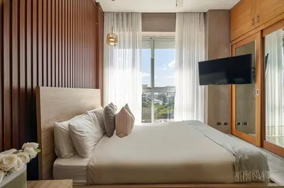 a bedroom with a large bed and a television at S802 Lujoso Apartamento Downtown Santo Domingo RD in Santo Domingo