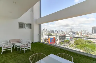 a balcony with a table and chairs and a view of the city at S802 Lujoso Apartamento Downtown Santo Domingo RD in Santo Domingo