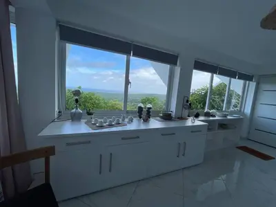 a white kitchen with a large window with a view at Apartamento panorámico vista al mar in Las Galeras