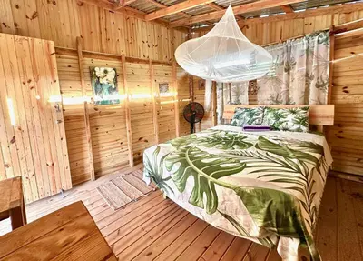 a bedroom with a bed in a wooden cabin at Beach Terrace Loft in Buen Hombre in Buen Hombre