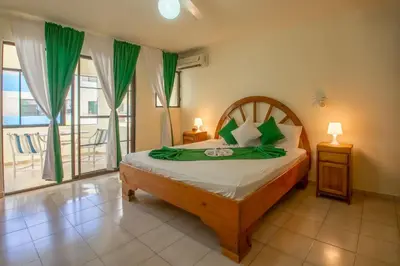 a bedroom with a large bed with green accents at Hotel Plaza Europa in Sosúa