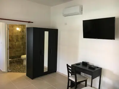 a room with a desk and a television and a bathroom at Coral Blanco Hotel in Sosúa