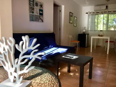 a living room with a blue couch and a table at Coral Blanco Hotel in Sosúa