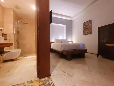 a bedroom with a bed and a bathroom with a shower at Heritage Residences Signature Collection in Santo Domingo