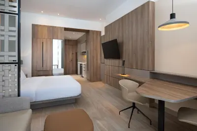 a bedroom with a bed and a desk and a table at Residence Inn by Marriott Santiago de los Caballeros in Santiago de los Caballeros