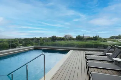 a large swimming pool with two chairs and a deck at Residence Inn by Marriott Santiago de los Caballeros in Santiago de los Caballeros