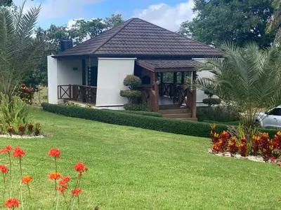 a small house with a lawn in front of it at Villa María Victoria, en Jarabacoa in Jarabacoa