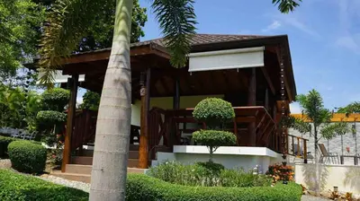 a house with a porch with a palm tree at Villa María Victoria, en Jarabacoa in Jarabacoa