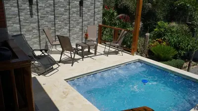 a small swimming pool with chairs and a table at Villa María Victoria, en Jarabacoa in Jarabacoa