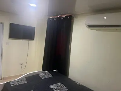 a bedroom with a black curtain and a tv at El anexos in Santiago de los Caballeros