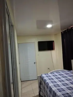 a bedroom with a bed and a tv on the wall at El anexos in Santiago de los Caballeros