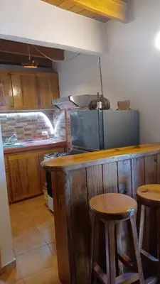 a kitchen with a counter with stools and a stove at Doña Mayra Aparta Hotel, Rustico in Las Terrenas