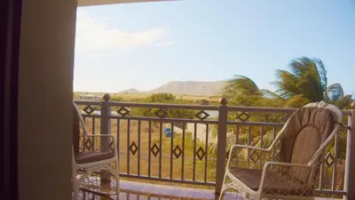 a balcony with two chairs and a view of the desert at Hotel Vista al Morro in San Fernando de Monte Cristi