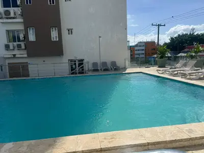 a large blue swimming pool next to a building at Perfecto para 3 personas. in Boca Chica