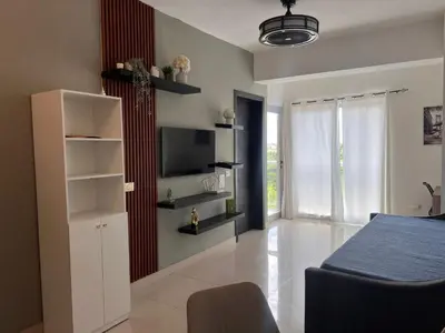 a bedroom with a bed and a tv on a wall at Perfecto para 3 personas. in Boca Chica