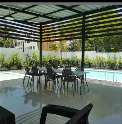 a patio with a table and chairs next to a pool at Estudio privado con vigilancia 24/7 con entrada independiente, in Santiago de los Caballeros