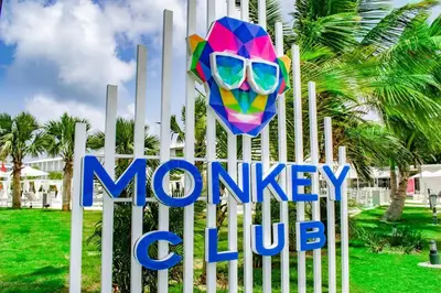 a sign for a monkey club with a colorful mask at Exclusive Villa * private Beach and Housekeeping in Punta Cana
