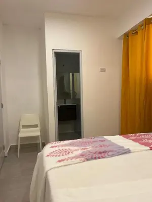 a bedroom with a bed and a chair and a mirror at HABITACIONES CON VISTA a LA BAHIA LA FAMILIA in Santa Bárbara de Samaná