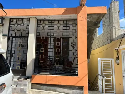 a building that has a table and chairs on it at HABITACIONES CON VISTA a LA BAHIA LA FAMILIA in Santa Bárbara de Samaná