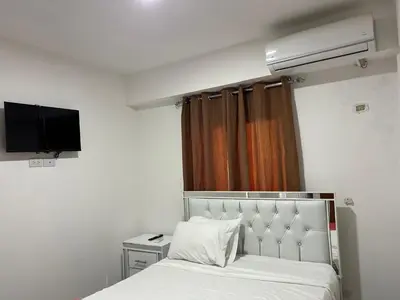 a bedroom with a bed and a television in it at HABITACIONES CON VISTA a LA BAHIA LA FAMILIA in Santa Bárbara de Samaná