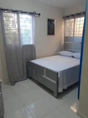 a bedroom with a bed and two windows at SDQ Apartamento Marbella 3 in La Ureña