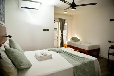 a bedroom with two beds and a ceiling fan at Honky Tonk Punta Cana in Punta Cana