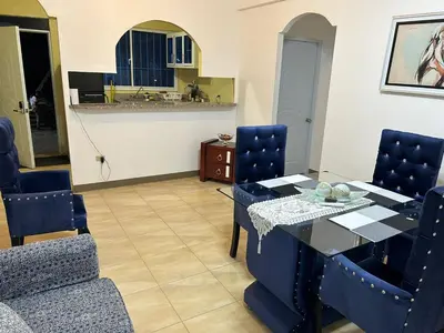 a dining room with a table and blue chairs at Apartamento pisó 1 parqueo, piscina, terraza y más in Azua de Compostela