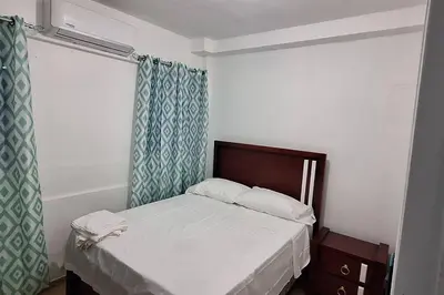 a small bedroom with a bed and a window at Apartamento pisó 1 parqueo, piscina, terraza y más in Azua de Compostela