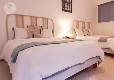 a bedroom with two large beds with white sheets and pillows at Hotel Plaza Kavia in Santo Domingo