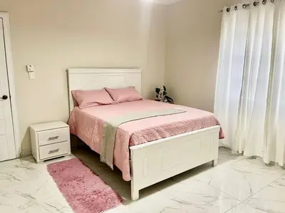 a bedroom with a bed with pink sheets and a pink blanket at Villa Familiar con Piscina cerca Av Ecológica in La Ureña