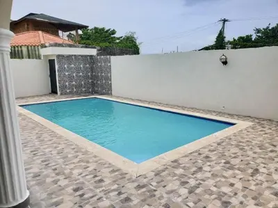 a swimming pool in front of a white wall at Villa Familiar con Piscina cerca Av Ecológica in La Ureña