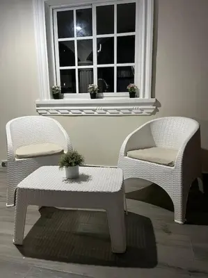 two chairs and a table in front of a window at Villa Familiar con Piscina cerca Av Ecológica in La Ureña