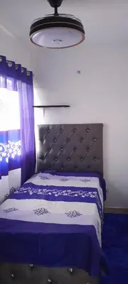 a bedroom with a bed with a blue and white blanket at Posada Mar azul in La Viva