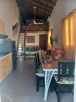 a kitchen and dining room with a table and chairs at Tropical Doña Mayra apartahotel in Las Terrenas