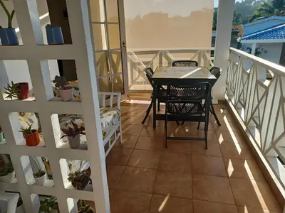 a balcony with a table and chairs on it at Tropical Doña Mayra apartahotel in Las Terrenas