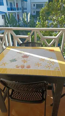 a table and a chair at a table with a tile top at Tropical Doña Mayra apartahotel in Las Terrenas