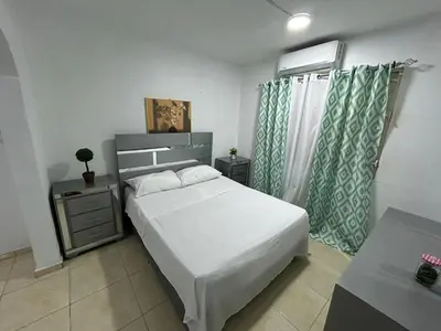 a bedroom with a white bed and a window at Casa en Villa Marchena azua in Azua de Compostela