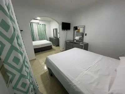 a bedroom with a bed and a mirror at Casa en Villa Marchena azua in Azua de Compostela