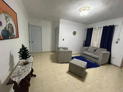 a living room with two couches and a table at Casa en Villa Marchena azua in Azua de Compostela