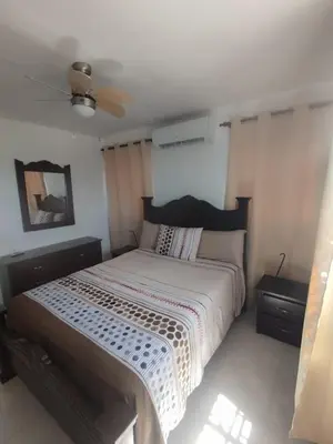 a bedroom with a bed and a ceiling fan at Caleta in La Romana