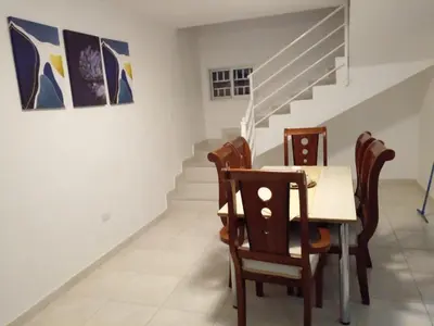 a dining room with a table and chairs and stairs at Caleta in La Romana