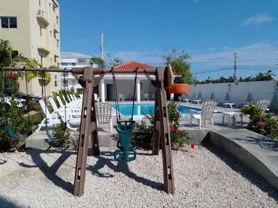 a swing set in a yard with a pool at Caleta in La Romana