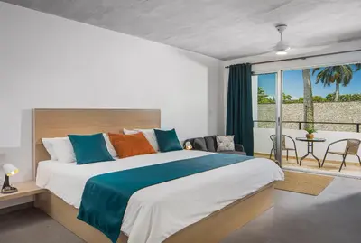 a bedroom with a large bed and a balcony at La Curadiña - Encuentro Surf Resort in Cabarete