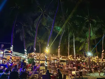 a crowd of people sitting on a beach at night at La Curadiña - Encuentro Surf Resort in Cabarete