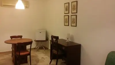a living room with a table and chairs and a desk at Hotel Tropicana Santo Domingo in La Viva