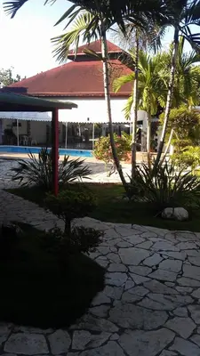 a pavilion with palm trees in front of a building at Hotel Tropicana Santo Domingo in La Viva
