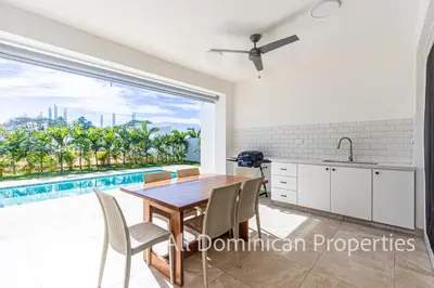 a dining room with a table and a large window at Sosua Ocean Village, Villas Nuevas con piscinas privadas! in Sosúa