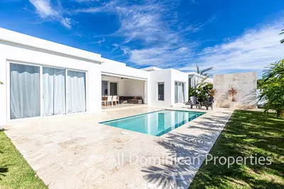 a villa with a swimming pool in front of a house at Sosua Ocean Village, Villas Nuevas con piscinas privadas! in Sosúa