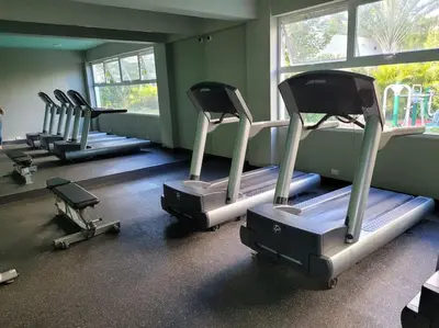 a gym with rows of exercise machines in a room at El mejor alojamiento en Santiago in Santiago de los Caballeros